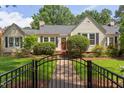 Charming single-story home with manicured lawn, black fence and a welcoming front porch and mature landscaping at 800 E Forest Hills Blvd, Durham, NC 27707