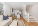Bright living room with hardwood floors, open layout to the kitchen, and staircase at 902 B Oakland Ave, Durham, NC 27705