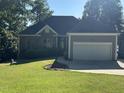 Charming single-story home with stone and siding, showcasing an attached garage at 929 Sagamore Dr, Louisburg, NC 27549