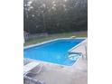 Inviting in-ground swimming pool surrounded by a concrete patio and secure fencing at 100 E Dale Dr, Oxford, NC 27565