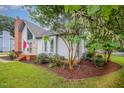 Charming home exterior features a brick chimney and nicely landscaped front yard at 100 Longneedle Ct, Raleigh, NC 27603