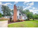 Charming home with large brick chimney, inviting entrance, and well-manicured lawn at 100 Longneedle Ct, Raleigh, NC 27603