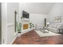 Bright living room features vaulted ceilings, brick fireplace, and hardwood floors at 100 Longneedle Ct, Raleigh, NC 27603