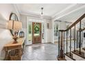 Welcoming foyer with tile flooring, staircase, and a view of the front door at 1008 Wolfs Bane Dr, Apex, NC 27539