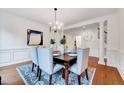 Formal dining room featuring elegant wainscoting, hardwood floors, and a stylish chandelier above the table at 101 Ironcreek Pl, Apex, NC 27539
