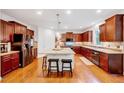 Spacious kitchen with granite countertops, stainless steel appliances, a large island, and rich wooden cabinetry at 101 Ironcreek Pl, Apex, NC 27539