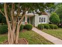 Beautiful home exterior with a well-manicured lawn and mature tree shading the facade at 10516 Cokesbury Ln, Raleigh, NC 27614