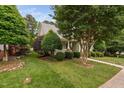Well-maintained front yard with lush greenery and mature trees surrounding the house at 10516 Cokesbury Ln, Raleigh, NC 27614