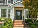 Inviting front entryway with brick steps, manicured bushes, and decorative glass door at 107 Ashwick Ct, Cary, NC 27513