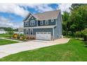 Stylish blue home features a large driveway and well-maintained landscaping at 108 Wilson Farm Ln, Clayton, NC 27527