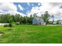 Expansive green lawn surrounds a blue two-story home on a sunny day at 108 Wilson Farm Ln, Clayton, NC 27527