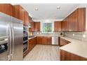 A modern kitchen with wood cabinets, stainless steel appliances, and a view from over the sink at 109 Longchamp Ln, Cary, NC 27519