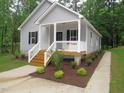 Attractive single-story home with a covered porch, complemented by lush greenery and a defined walkway at 119 Oak Ridge Rd, Franklinton, NC 27525