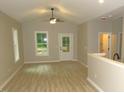 Well-lit living room with vaulted ceilings, light wood flooring, neutral tones, and large windows at 119 Oak Ridge Rd, Franklinton, NC 27525