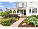 Beautiful two-story home featuring a welcoming front porch with landscaped garden beds at 1205 Quincy Cottage Rd, Hillsborough, NC 27278