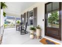 Inviting front porch with rocking chairs, potted plants, and an elegant entryway at 1205 Quincy Cottage Rd, Hillsborough, NC 27278