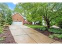 Charming brick home with a spacious driveway and lush greenery, offering an inviting curb appeal at 123 Chimney Rise Dr, Cary, NC 27511