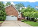 Beautiful brick home featuring an attached two-car garage, lovely landscaping, and an inviting curb appeal at 123 Chimney Rise Dr, Cary, NC 27511