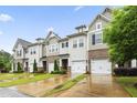 Row of townhomes with brick and vinyl siding, attached garages, and green lawns at 127 Manordale Dr, Chapel Hill, NC 27517