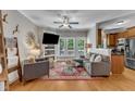 Comfortable living room with hardwood floors, a ceiling fan, and views of the outdoors through large windows at 137 Lanigan Pl, Cary, NC 27513