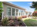 The backyard has a grass area, landscaping and an exterior view of the back of the house with lots of windows at 1405 Ventnor Pl, Cary, NC 27519
