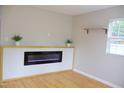 Bright living room with blonde floors and an electric fireplace beneath a floating shelf at 1536 Granville Street, Burlington, NC 27215