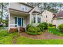 Close up of front entrance with brick steps, blue door and surrounding landscaped garden at 1724 Briarforest Pl, Raleigh, NC 27615
