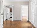 Open living room with hardwood floors and open doorway view into the kitchen and dining room at 1724 Briarforest Pl, Raleigh, NC 27615