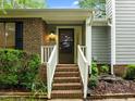 Welcoming front entrance with classic brick steps, bright white railing, and a cozy porch light adding charm at 173 Clancy Cir, Cary, NC 27511