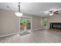 Bright living room with modern flooring, fireplace, ceiling fan, and sliding glass door leading to outdoor space at 173 Clancy Cir, Cary, NC 27511