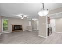 Open living room with modern flooring, brick fireplace, and a ceiling fan for comfortable, stylish living at 173 Clancy Cir, Cary, NC 27511