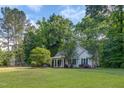 Inviting one-story home with a spacious lawn and mature trees surrounding the property at 175 Fox Run Rd, Youngsville, NC 27596