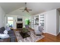 Bright living room with fireplace, vaulted ceiling, and custom built-in shelving at 175 Fox Run Rd, Youngsville, NC 27596