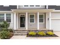 View of the inviting front porch with stone steps, columns and decorative landscaping at 188 Karlov Rd, Garner, NC 27529