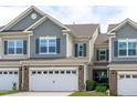 Charming townhouse featuring a stone front, neutral siding, and a convenient two-car garage at 210 Mayfield Dr, Apex, NC 27539