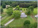 Aerial view of country home on a large lot with mature trees and outbuildings at 2227 Us-15, Creedmoor, NC 27522