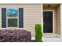 Charming home exterior with dark shutters, a black front door, and manicured landscaping at 246 Spark St, Raleigh, NC 27606