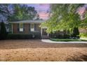 Brick home with a manicured lawn and mature trees, featuring a walkway to the front door at 2800 Glen Burnie Dr, Raleigh, NC 27607