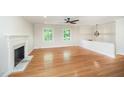 Bright living room with hardwood floors, a fireplace, and two large windows at 2800 Glen Burnie Dr, Raleigh, NC 27607