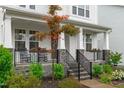 Charming front porch featuring stone accents, landscaping, and a cozy seating area at 2924 Watering Hole Way, Apex, NC 27502