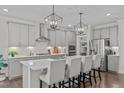 Modern kitchen featuring seating at the island, stainless appliances, and stylish pendant lighting at 2924 Watering Hole Way, Apex, NC 27502