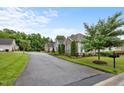 A peaceful community street view, with perfectly manicured lawns and beautiful landscaping at 306 Faith Dr, Gibsonville, NC 27249