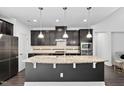 Gourmet kitchen featuring granite countertops, stainless steel appliances, and modern lighting at 310 Alamosa Pl, Cary, NC 27519