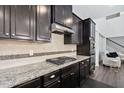 Gourmet kitchen featuring granite countertops, dark cabinets, and stainless steel appliances at 310 Alamosa Pl, Cary, NC 27519