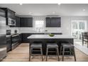 Modern kitchen features sleek black cabinetry, stainless steel appliances, and a center island with barstool seating at 314 N Coral Bells Way, Four Oaks, NC 27524