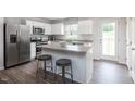 Bright kitchen featuring stainless steel appliances, an island with seating, and white cabinetry at 314 N Coral Bells Way, Four Oaks, NC 27524