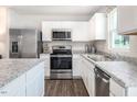 Modern kitchen featuring white cabinets, stainless steel appliances, and granite countertops at 314 N Coral Bells Way, Four Oaks, NC 27524