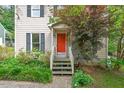 Inviting front entrance with an orange door, lush greenery, and a covered porch at 3405 Bonaparte Way, Durham, NC 27707