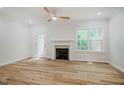 Bright living room featuring a cozy fireplace, ceiling fan, and wood floors at 361 Anterbury Dr # B, Apex, NC 27502