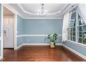 Bright dining room features hardwood floors, decorative molding, stylish lighting, and a large window at 3904 Freemark Ln, Fuquay Varina, NC 27526